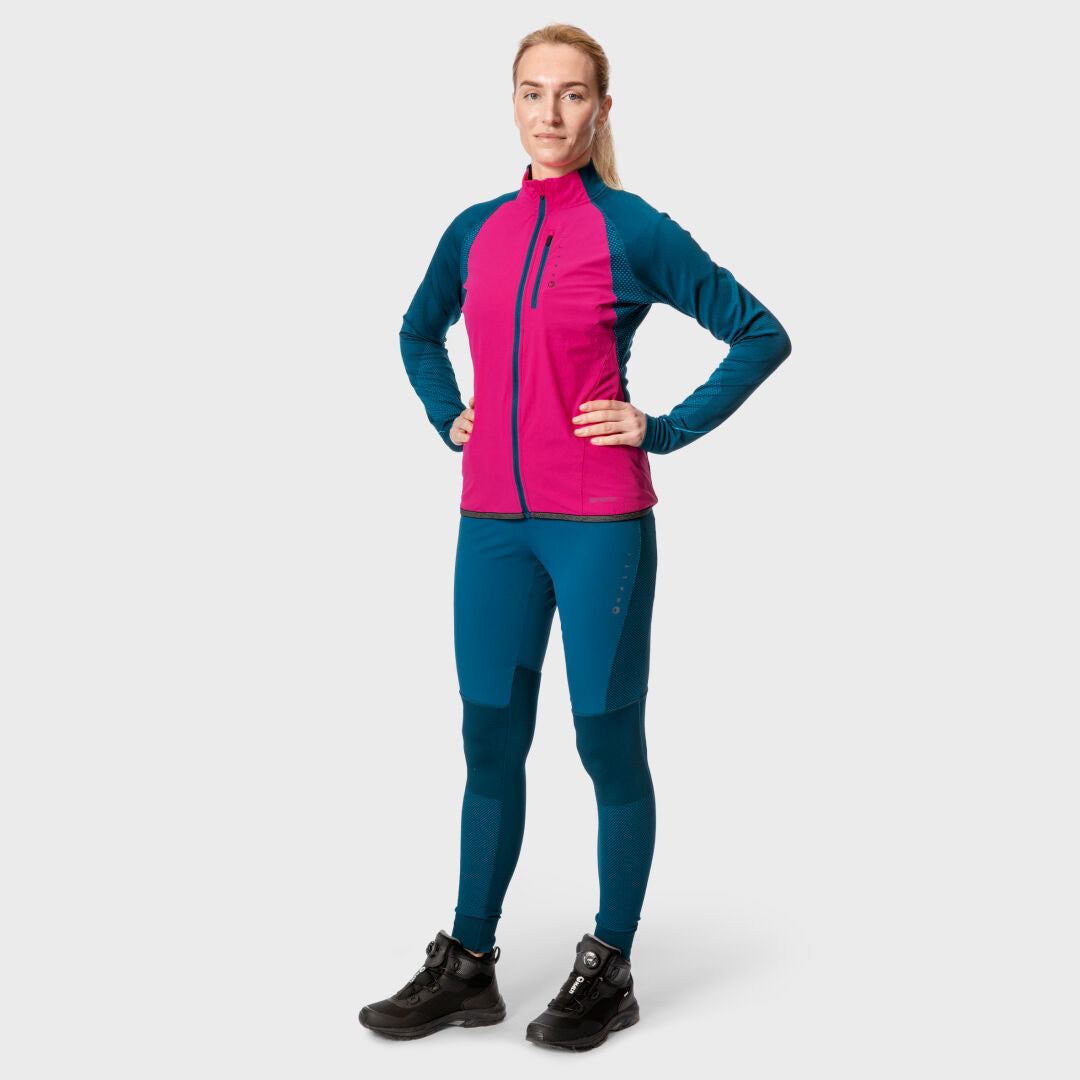 Eine Frau blickt nach vorne und trägt nahtlose Halti Tracks-Strumpfhosen für Damen in Pink und Blau sowie schwarze Wanderstiefel.