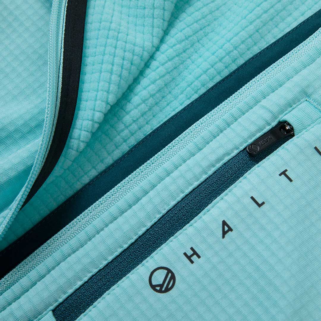 Nahaufnahme einer hellblauen Halti Forerunner Damen Midlayer Jacke aus recycelten Materialien mit sichtbarem Reißverschluss.