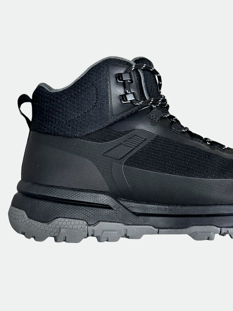 Nahaufnahme von Halti Fara 3 DX Mid Outdoor Schuhe Herren mit grauer Lauffläche, schwarzen Schnürsenkeln und Metallösen auf hellgrauem Hintergrund.