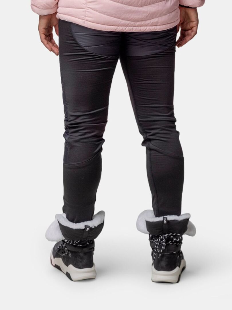 Person in schwarzer Hose, hellrosa Jacke und Halti Jeti DX Winterstiefel Damen mit weißem Fell, von hinten gesehen.