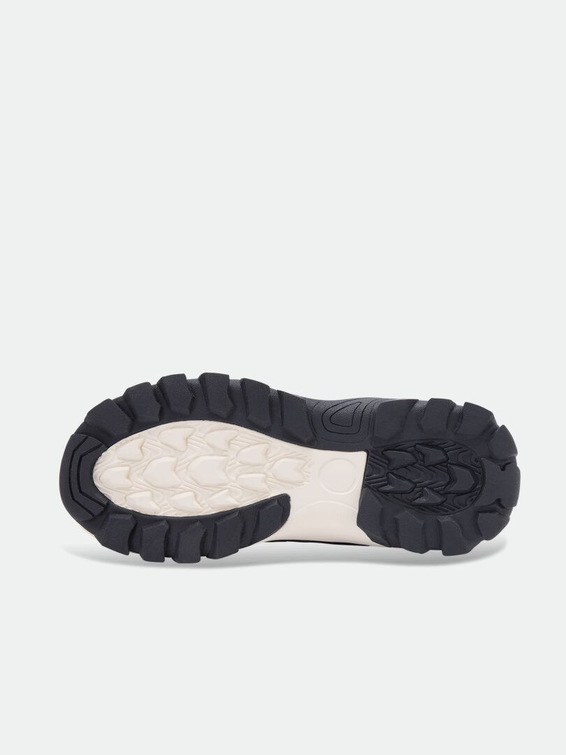 Dunkle Profilsohle aus Gummi mit strukturiertem, cremefarbenem Mittelteil an den Tribe Dada DX Outdoor-Schuhen für Kinder.