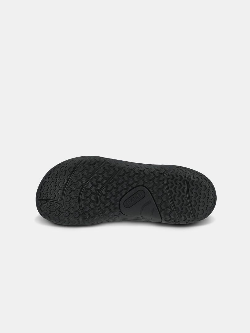 Schwarze Gummisohle des Halti Tuntuma Mid DX Barfußschuhs für Damen, ideal für Outdoor-Abenteuer, hier von unten auf weißem Hintergrund abgebildet.