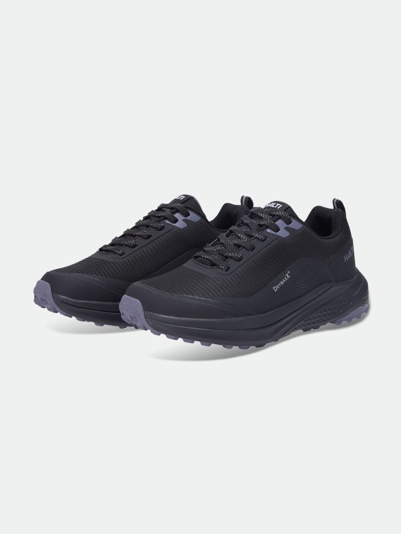 Halti Asento DX Outdoor-Schuhe für Damen in Schwarz mit grauen Sohlen und Schnürsenkeln, abgebildet vor einem einfarbigen hellen Hintergrund.