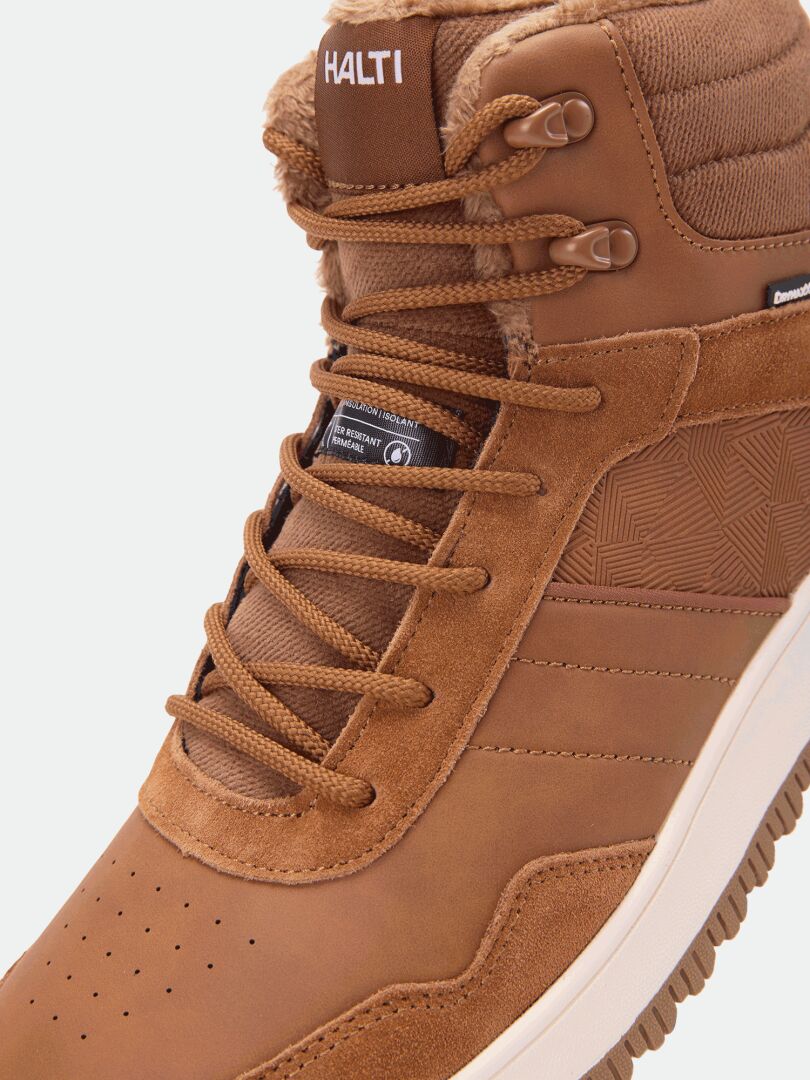Nahaufnahme der braunen Halti Metso Mid DX Winterschuhe für Herren mit Schnürsenkeln, strukturierten Details und Markenlogos auf der Zunge und an der Seite.