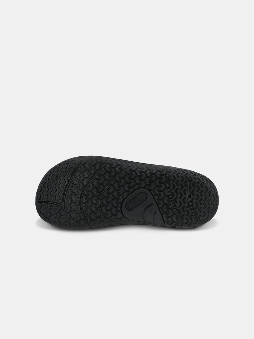 Halti Tuntuma DX Barfußschuh für Damen, schwarze Gummisohle mit strukturiertem Profil, von unten auf weißem Hintergrund betrachtet.