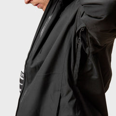 Eine Person öffnet den Achselschlitz einer Halti Vertica DX Skijacke Herren und gibt den Blick auf ein gestreiftes Hemd darunter frei.