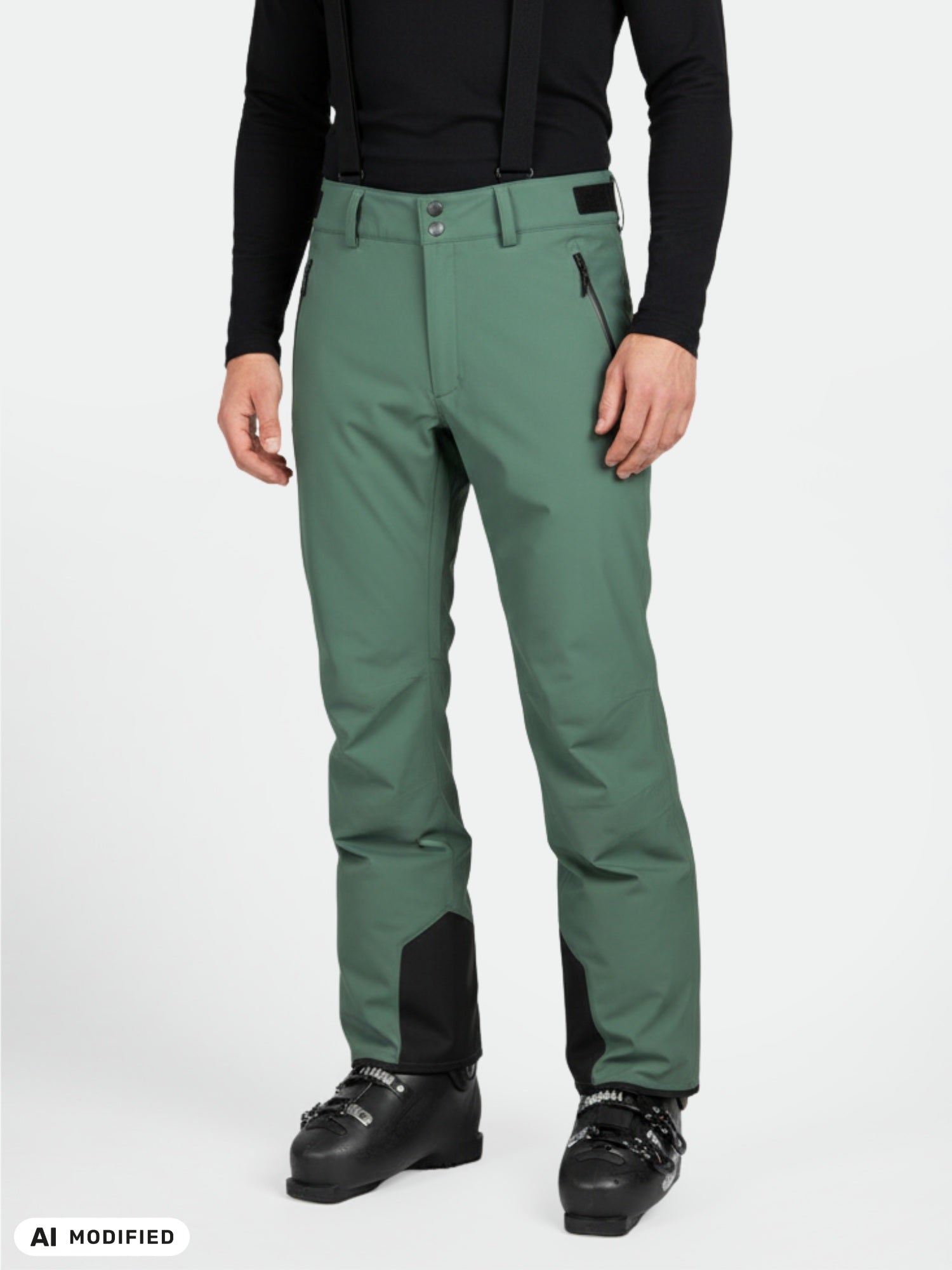 Eine Person in einer „Halti Trusty DX“ Skihose für Herren (grün) mit schwarzen Hosenträgern, Stiefeln und einem schwarzen Langarmhemd.