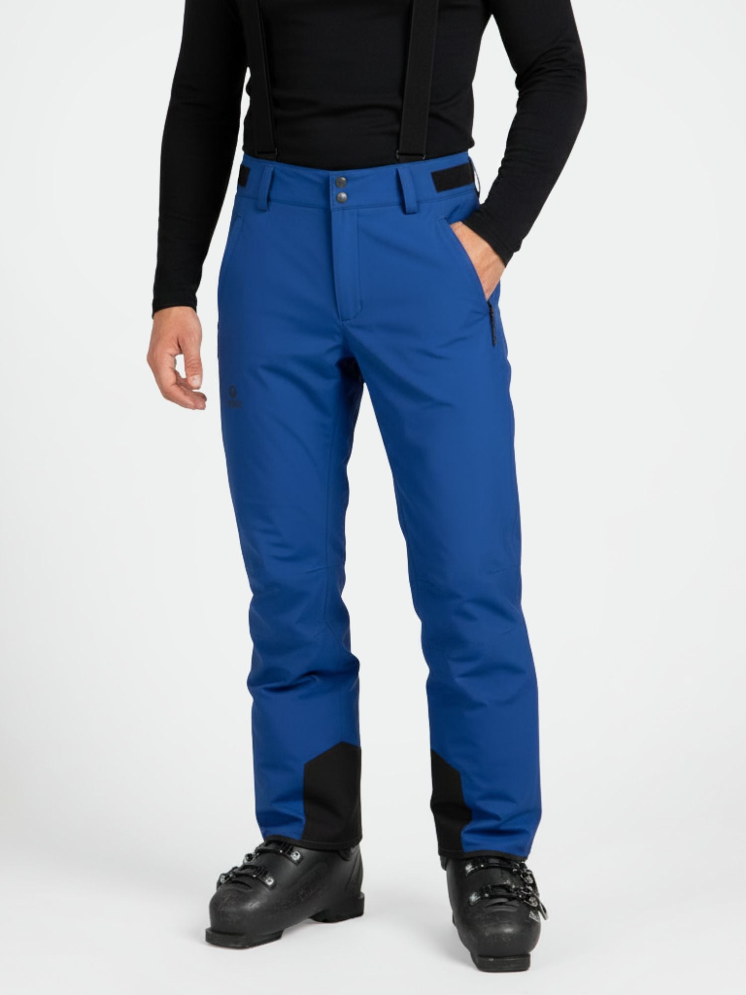 Eine Person in Halti Trusty DrymaxX Skihose Herren mit schwarzen Hosenträgern, schwarzen Stiefeln und einem schwarzen langärmeligen Oberteil steht aufrecht.