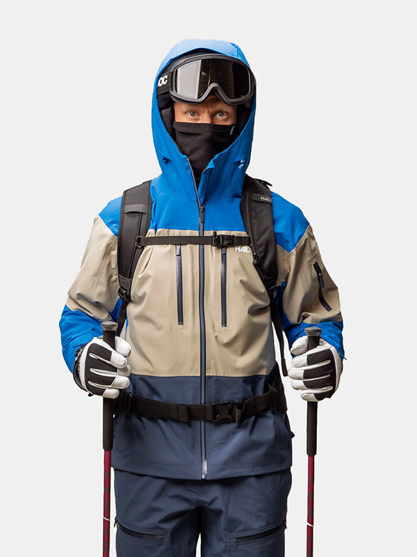 Person in Halti Rizle Unisex 3L DX Skijacke mit Primaloft, Handschuhen, Skibrille, Maske, mit Skistöcken in der Hand, Blick nach vorne.