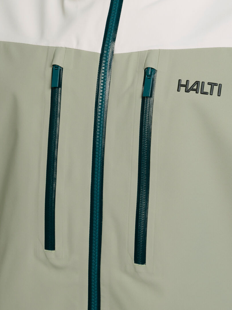 Nahaufnahme einer hellgrün-weißen Halti Rizle Unisex 3L DX Skijacke mit zwei vertikalen Brusttaschen und einem Logo auf der Brust.