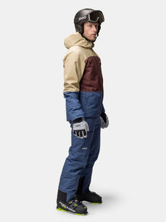 Eine Person mit Helm und Skibrille trägt die Halti Melvik DX Skijacke Herren in einem farblich abgestimmten Skianzug.