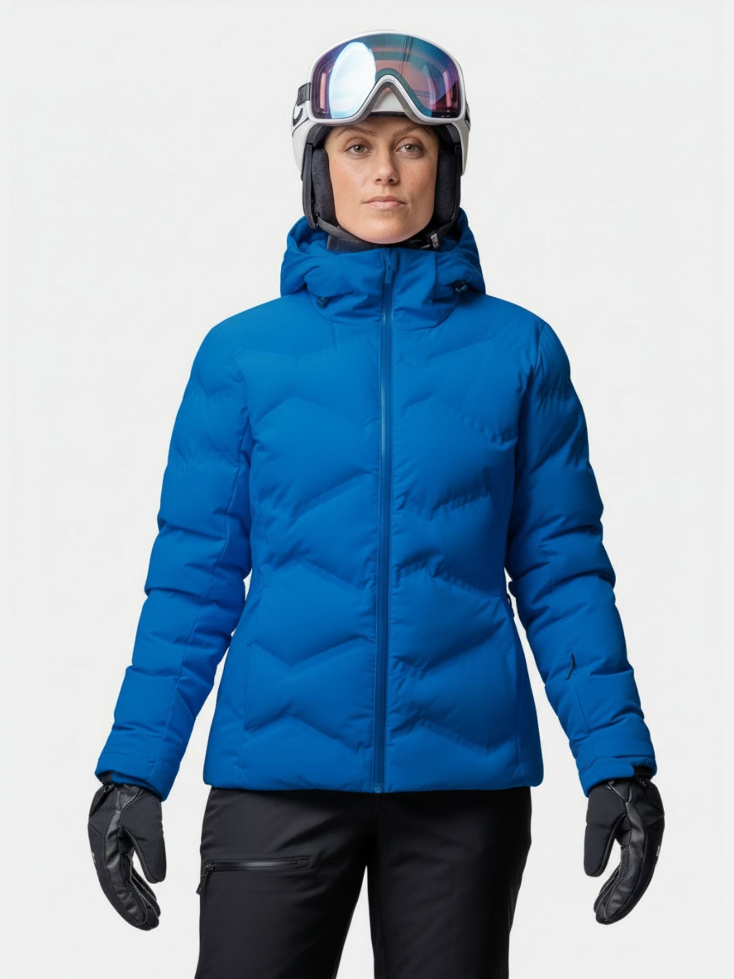 Person trägt die Halti Nordic Arcty II Skijacke Damen beim Skifahren mit Helm und Skibrille vor schlichtem Hintergrund.