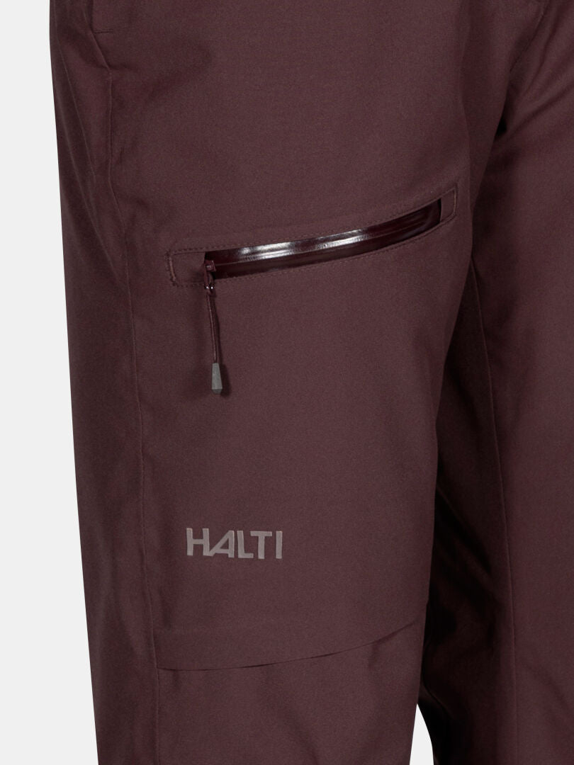 Nahaufnahme der kastanienbraunen Carvey II DX Skihose Damen von Halti mit Reißverschlusstasche, Logo und DrymaxX-Technologie für Komfort.