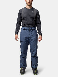 Eine Person in einem schwarzen langärmeligen Hemd und Halti Carvey II DX Skihose Herren mit Hosenträgern steht mit dem Gesicht nach vorne.