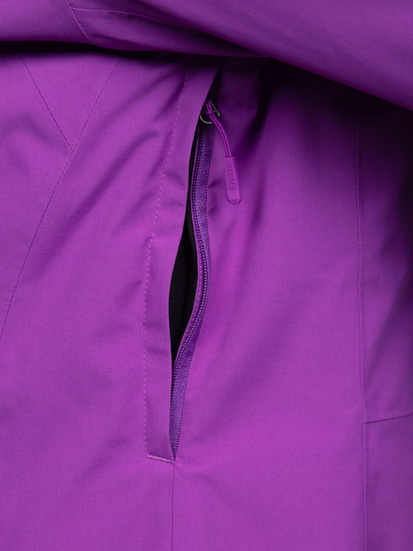 Nahaufnahme einer violetten Halti Melvik DX Skijacke für Damen mit wärmendem Futter und einer Seitentasche mit Reißverschluss und Marken-Reißverschlusszug.