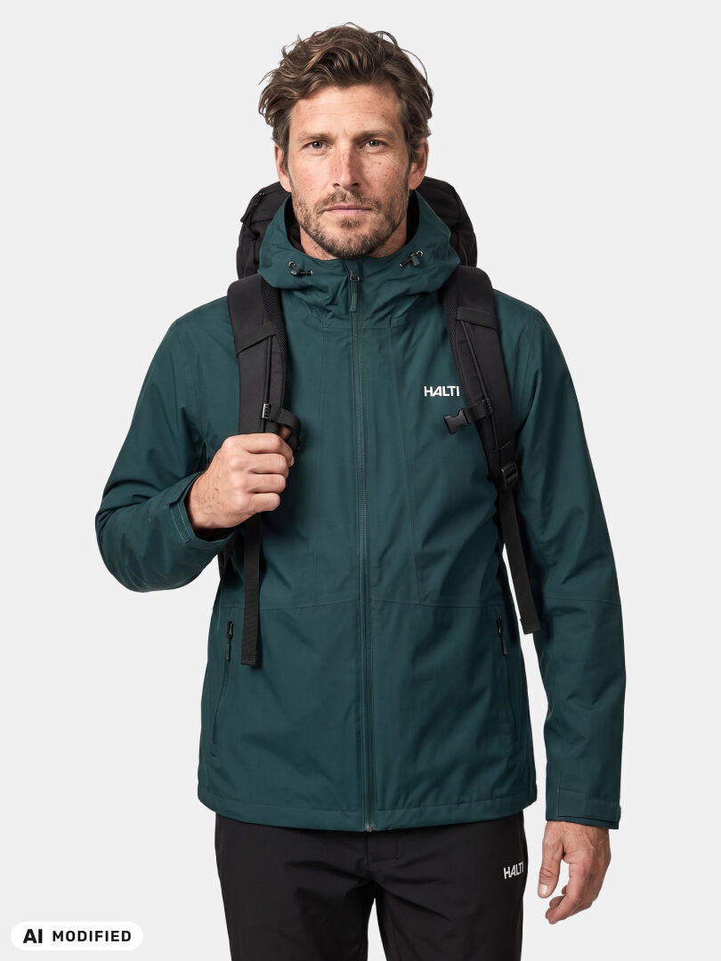 Ein Mann in einer „Halti Forter DX Regenjacke Herren“ und einem schwarzen Rucksack, der vor einem schlichten weißen Hintergrund nach vorne blickt.