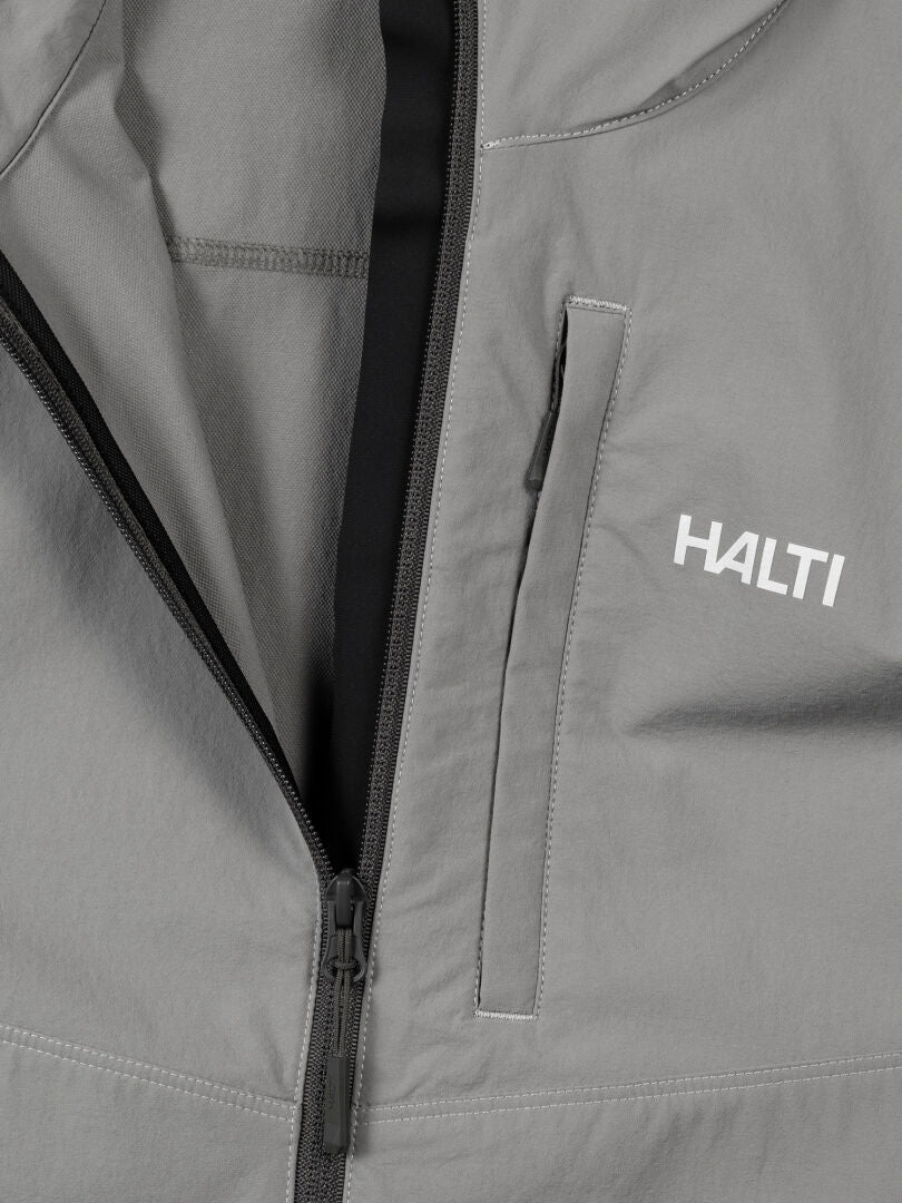 Nahaufnahme der Halti Pallas Evo X-stretch Jacke Herren in grau mit Reißverschluss, Brusttasche und Logo auf der rechten Seite.