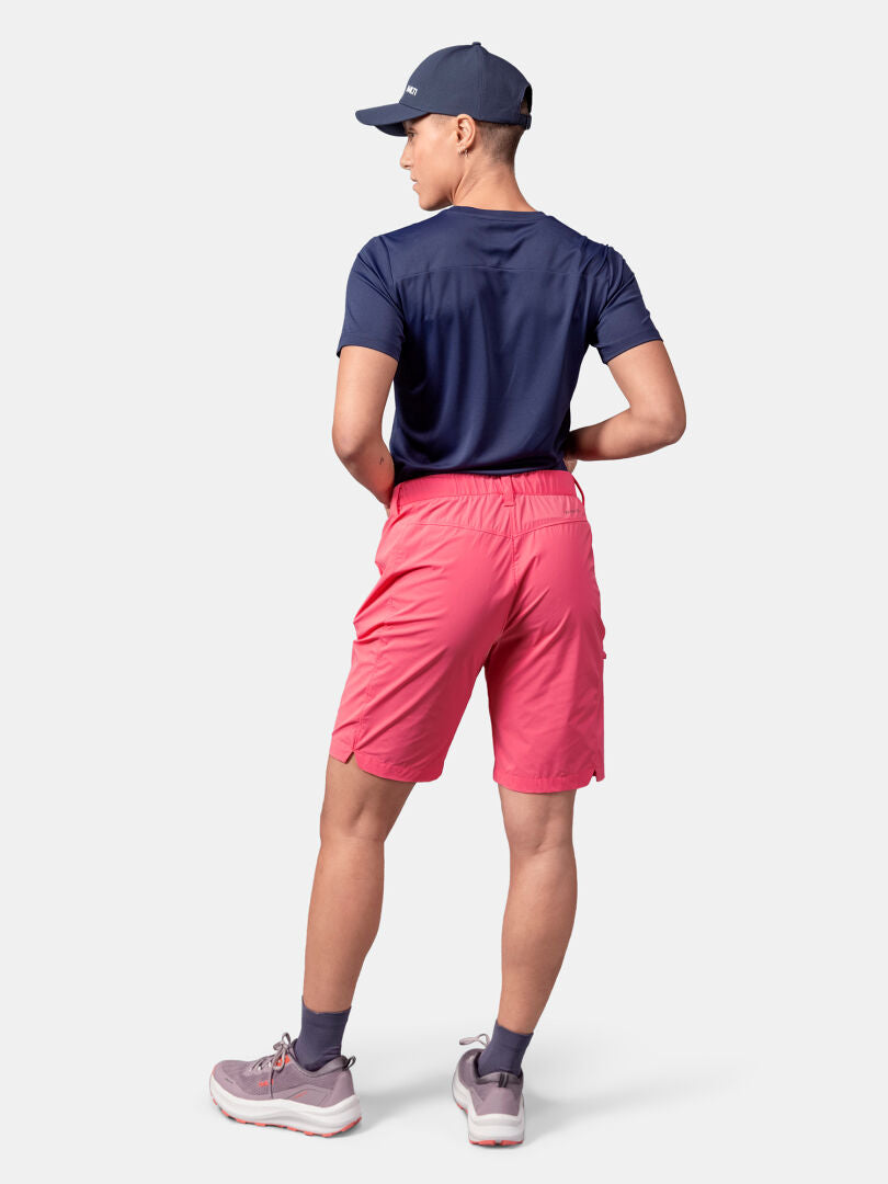Die Person blickt nach vorne und trägt Halti Pallas Cool Shorts Damen, eine marineblaue Kappe und ein Hemd sowie graue Turnschuhe - ideal für draußen.