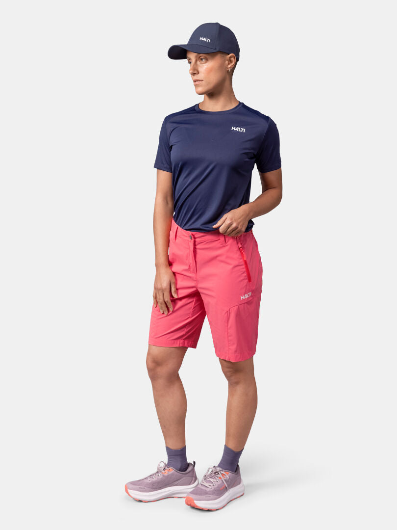 Ich trage eine marineblaue Mütze und ein Hemd, Halti Pallas Cool Shorts Damen und Turnschuhe - perfekt für Outdoor-Aktivitäten.