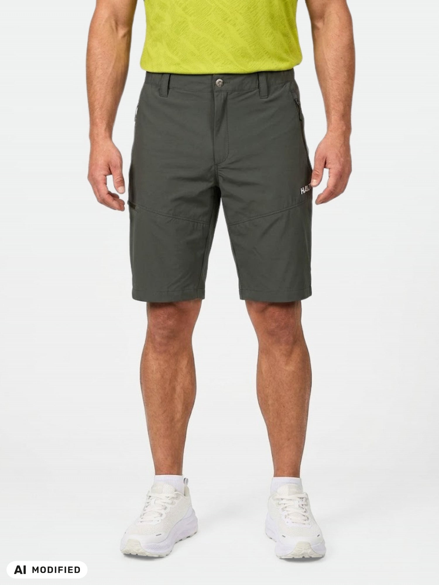 Vor einem weißen Hintergrund trägt jemand die „Halti Pallas Cool X-Stretch Shorts Herren“, ein limettengrünes Hemd und weiße Sneaker.