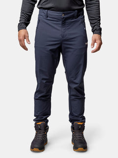 Ein Mann in marineblauer Halti Finholma X-Stretch-Hose, schwarzem Langarmshirt und Wanderschuhen steht mit dem Gesicht nach vorne.