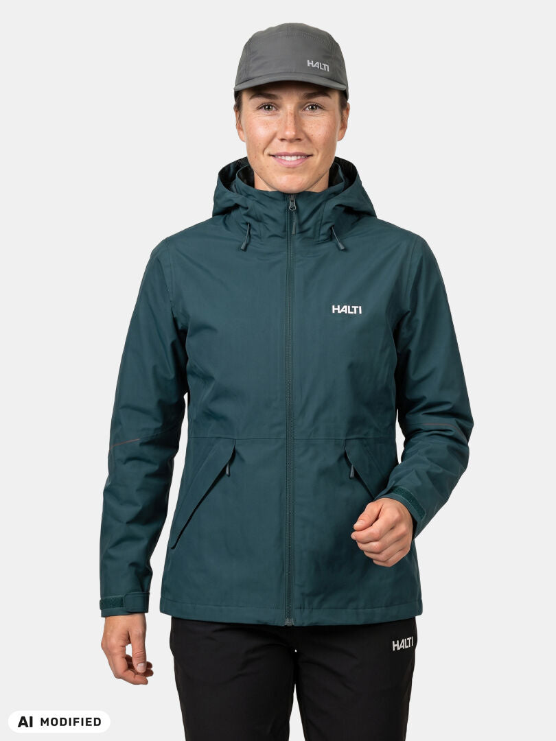 Eine Person in einer „Halti Loito 3-in-1 DX“-Jacke für Damen, einer schwarzen Hose und einer grauen Mütze steht vor einem schlichten weißen Hintergrund.