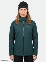 Eine Person trägt eine dunkelgrüne, wasserdichte Kaltimo DX Regenjacke Damen mit Reißverschluss und eine schwarze Mütze.