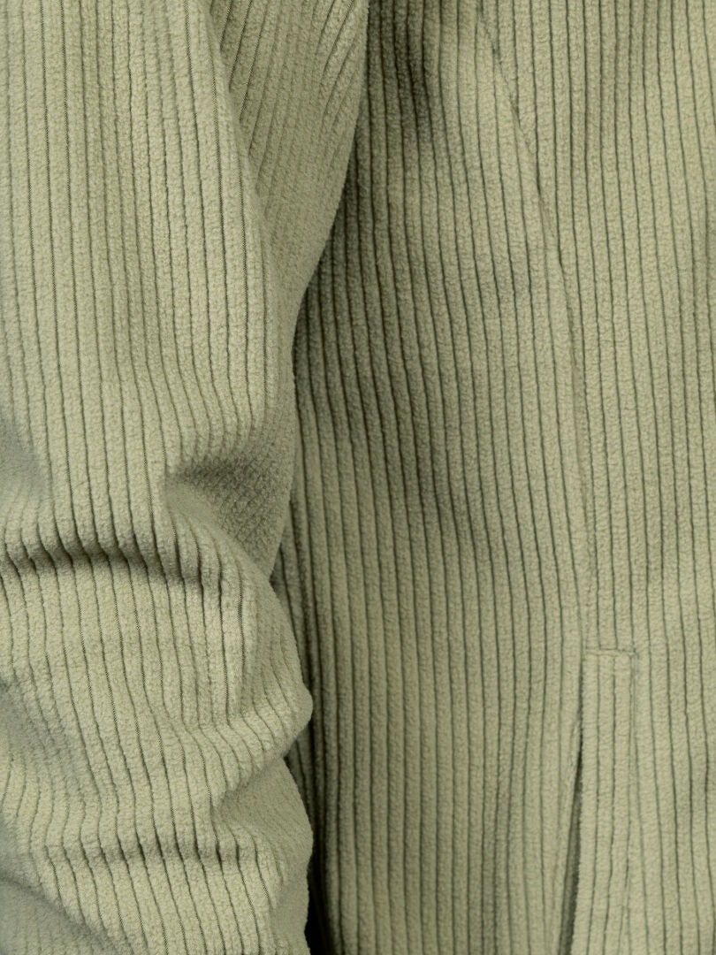Nahaufnahme der Halti Loito 3-in-1 DX Jacke für Herren aus hellgrünem Cord, die die gerippte Struktur sowie Ärmel und Tasche zeigt.