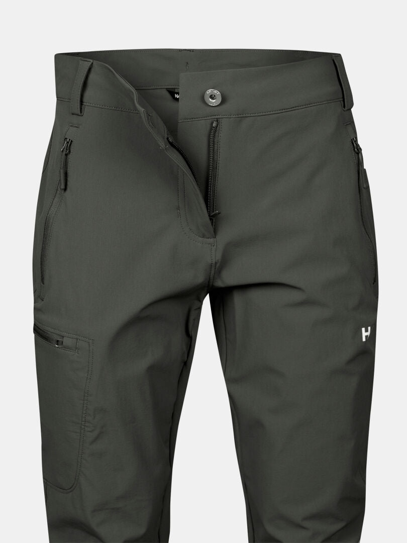 Ein Paar Halti Pallas X-stretch Hose Damen Plus in dunkelgrün mit Reißverschlusstaschen, hergestellt aus atmungsaktivem X-stretch Material.