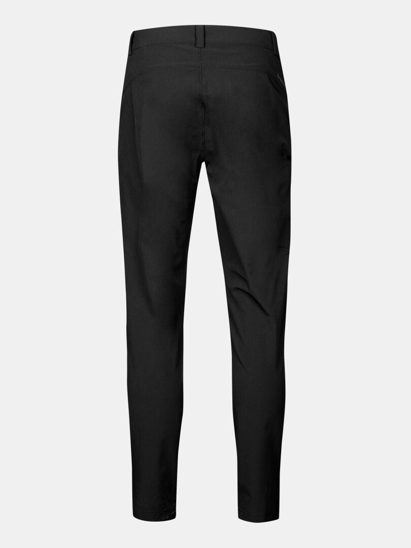 Rückenansicht der Halti Pallas X-stretch Hose Herren in schwarz, mit Gürtelschlaufen und spitz zulaufendem Bein auf unifarbenem Grund.