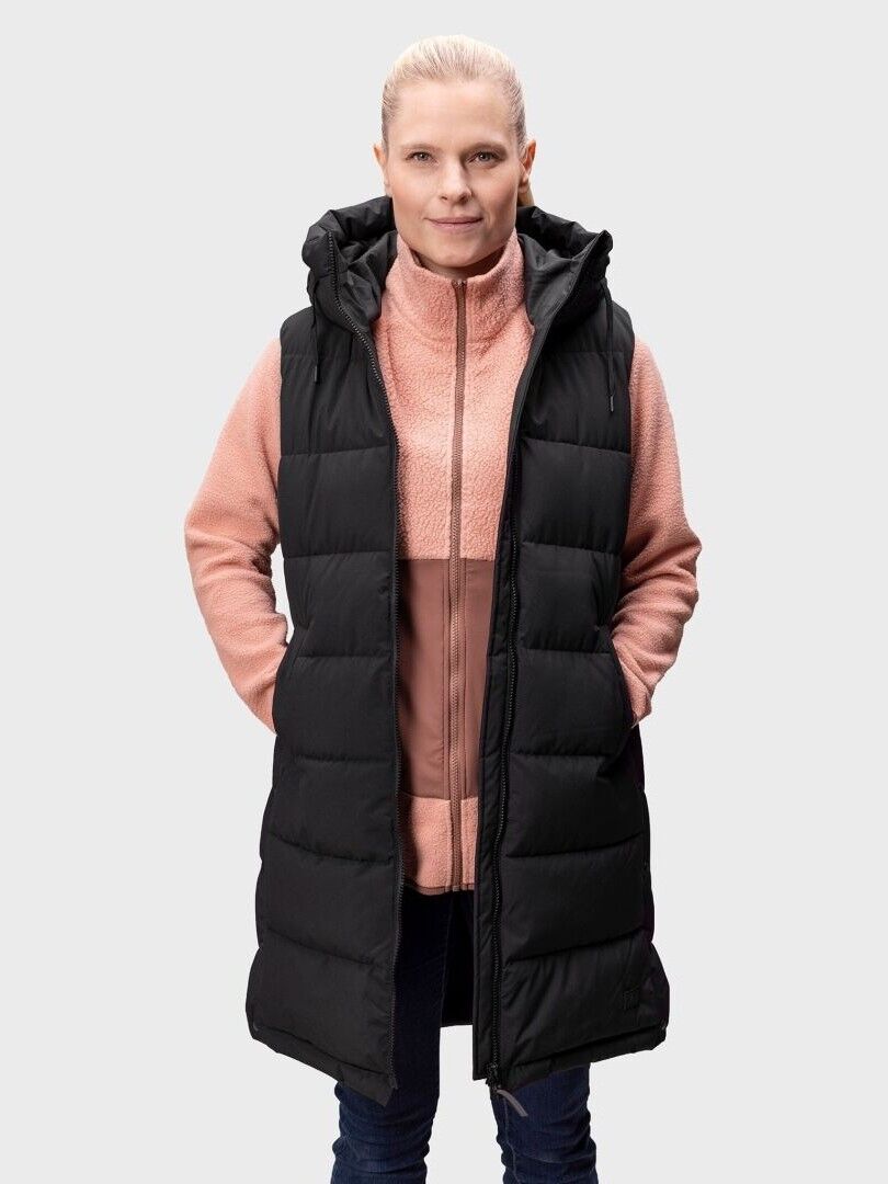 Eine Frau steht in einem rosafarbenen Zip-up und Halti Penger Puffer Weste Damen, die Hände in die Taschen gesteckt.