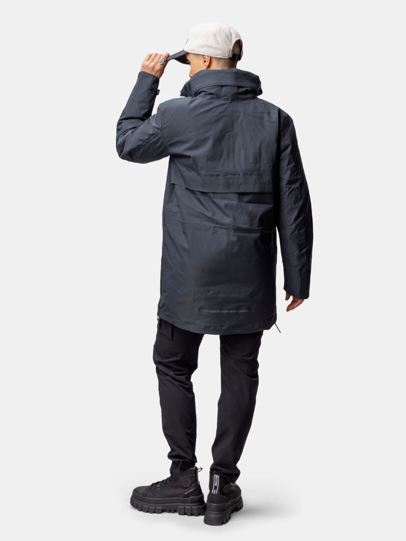 Person steht mit dem Rücken zur Kamera in Halti Synkas 3in1 DrymaxX Parka Damen, perfekt für stilvolle Outdoor-Enthusiasten.