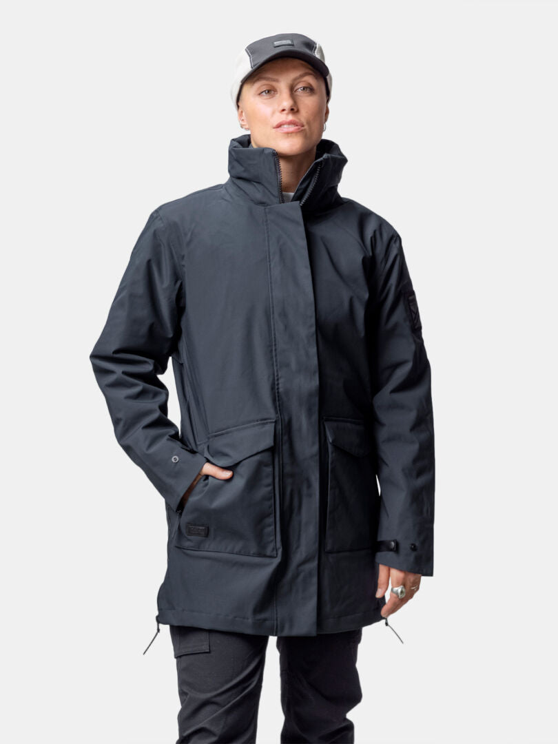 Outdoor-Enthusiast trägt Halti Synkas 3in1 DrymaxX Parka Damen: dunkel, lang, wasser- & winddicht, mit Kapuze.