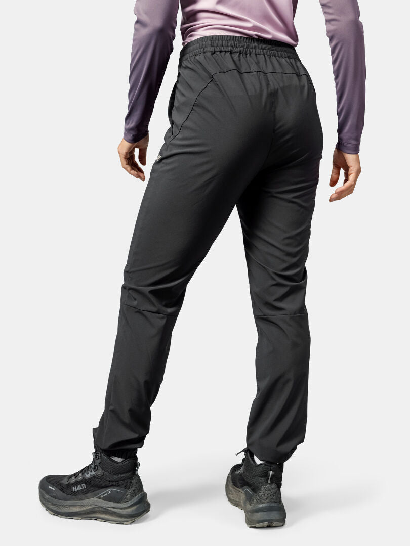 Eine Person in schwarzer Halti Grets Jogginghose Damen und einem lavendelfarbenen Oberteil, von hinten gesehen, in Quick Dry Lite Stretch Bekleidung.