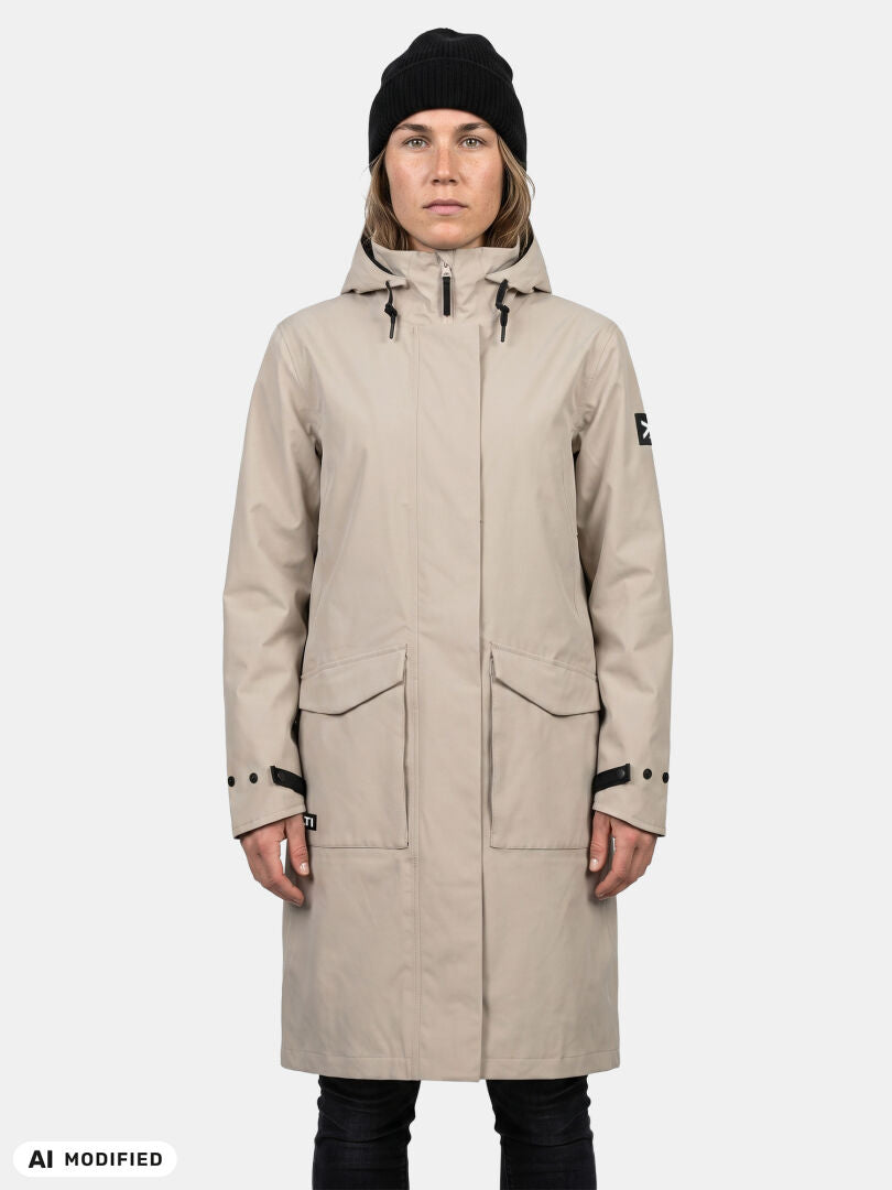 Model in einer Halti Tokoi II DX Parkajacke für Damen, beige, mit schwarzer Mütze und Hose, vor einem hellen Hintergrund.