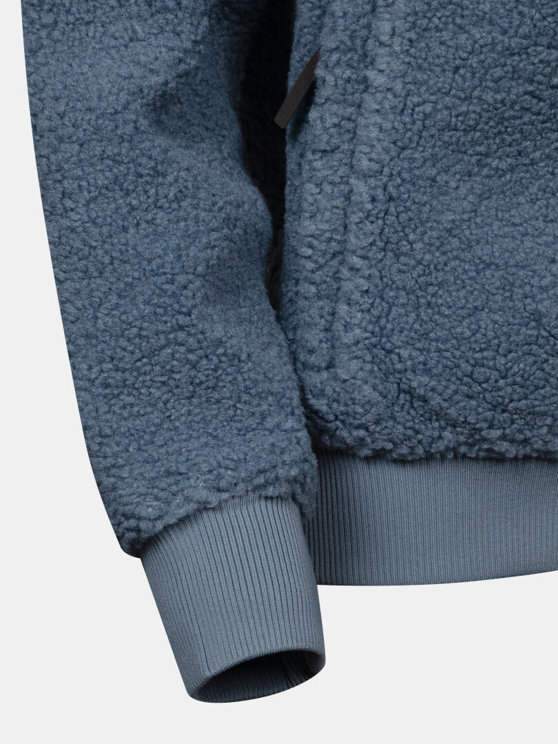 Nahaufnahme eines Ärmels der Halti Lykky Fleece-Jacke für Damen, mit geripptem Bündchen und Nahtdetails, die die Stoffstruktur hervorheben.