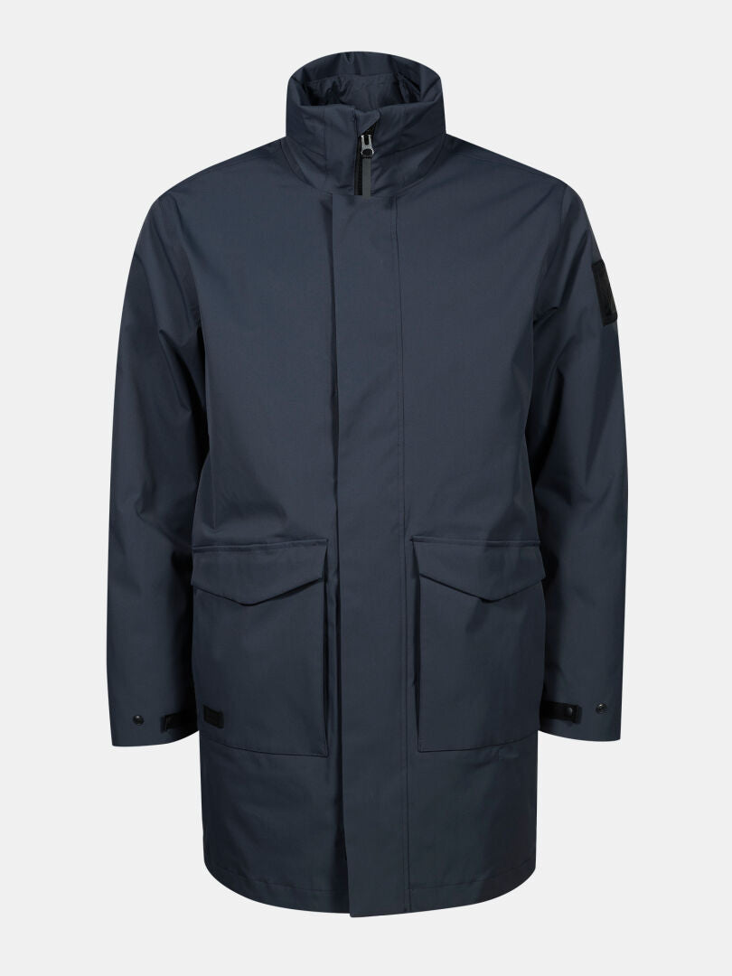 Der Halti Synkas II 3in1 DX Parka Herren, eine marineblaue, wasserdichte Jacke mit hohem Kragen und zwei großen Taschen, ist schlicht gehalten.