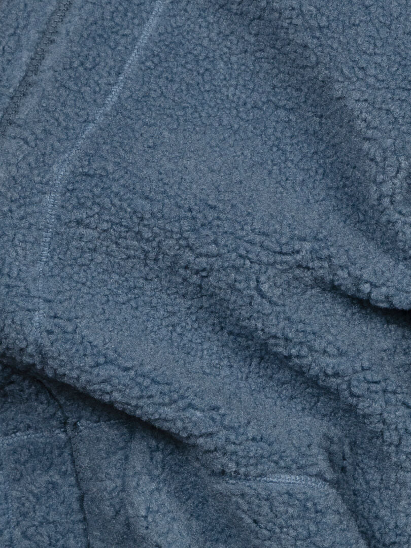 Nahaufnahme der Halti Lykky Fleecejacke für Herren, die den weichen, strukturierten und sanft gefalteten Fleece-Stoff hervorhebt.