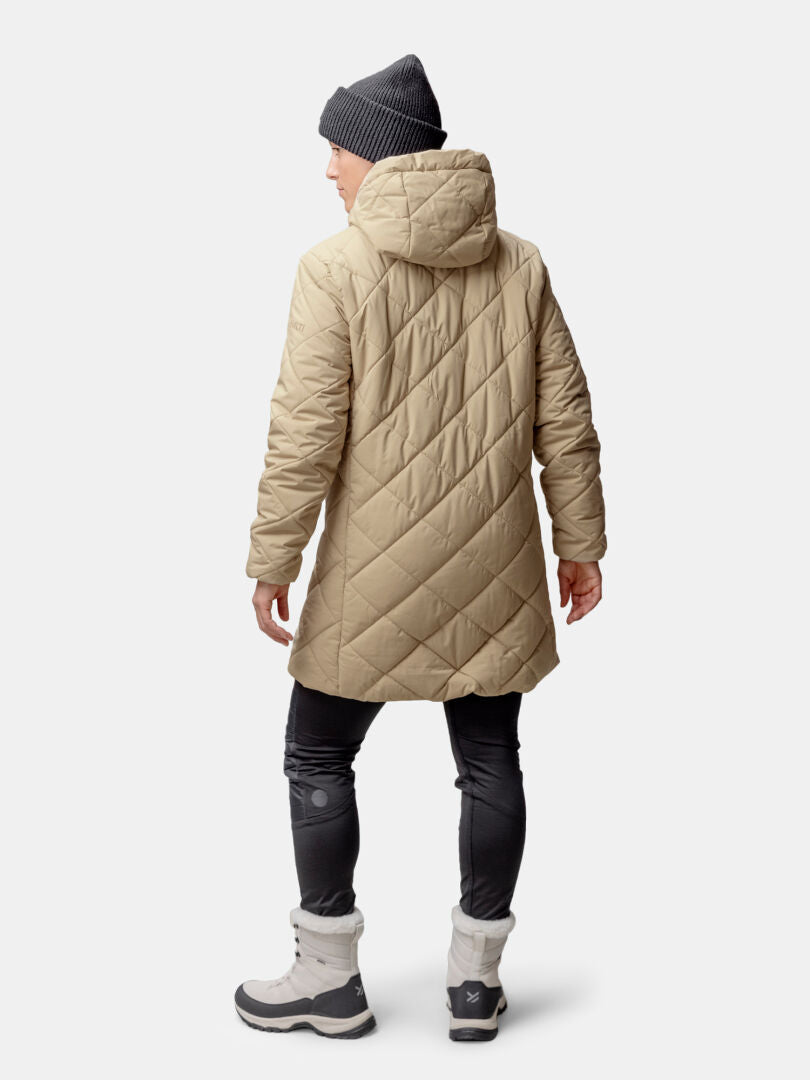 Frau in Halti Haapa Steppmantel Damen, graue Mütze, schwarze Hose und graue Stiefel, von hinten gesehen.