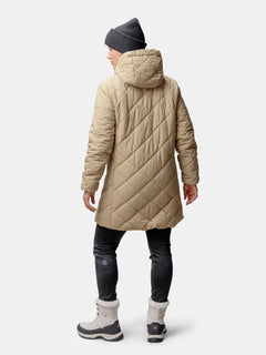 Frau in Halti Haapa Steppmantel Damen, graue Mütze, schwarze Hose und graue Stiefel, von hinten gesehen.