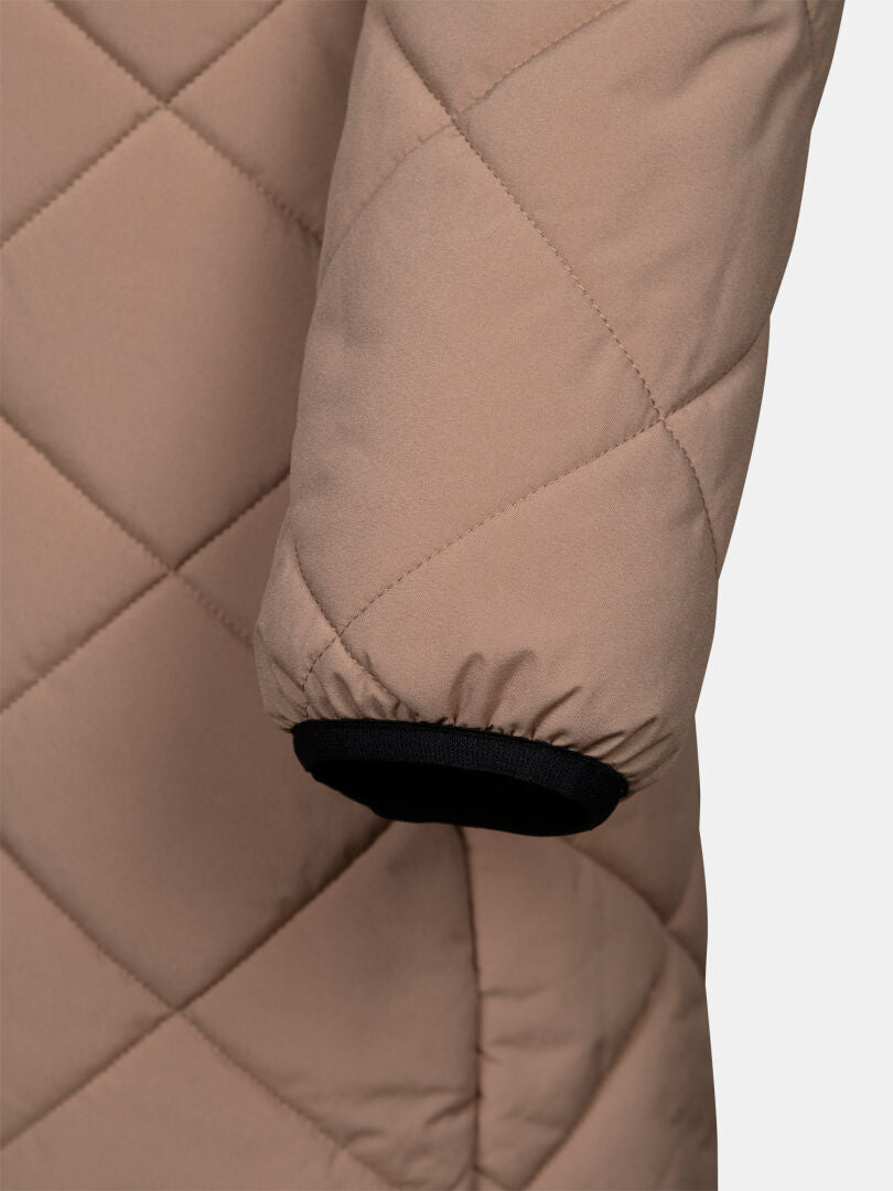Nahaufnahme eines Ärmels des Modells „Haapa Steppmantel Damen“ von Halti, beige mit schwarz eingefasstem Bündchen, vor einfarbigem Hintergrund.