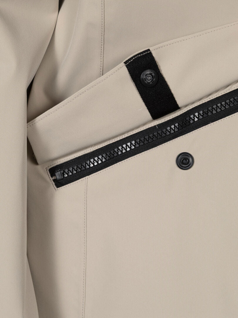 Nahaufnahme der Halti Tokoi DX Jacke Damen in Beige mit schwarzem Reißverschluss und einer Druckknopftasche.