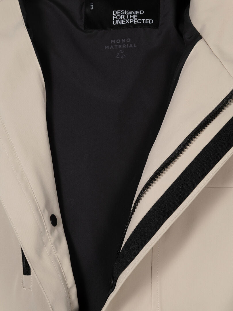 Nahaufnahme der Halti Tokoi DX Jacke Herren in Beige mit schwarzem Reißverschluss und Futter, das die Wetterschutz-Eigenschaften hervorhebt.