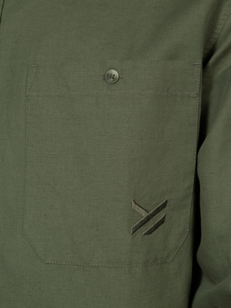 Nahaufnahme der Halti Notsgi Langarm Hemd Herren Tasche mit Knopf und gesticktem Logo darunter.