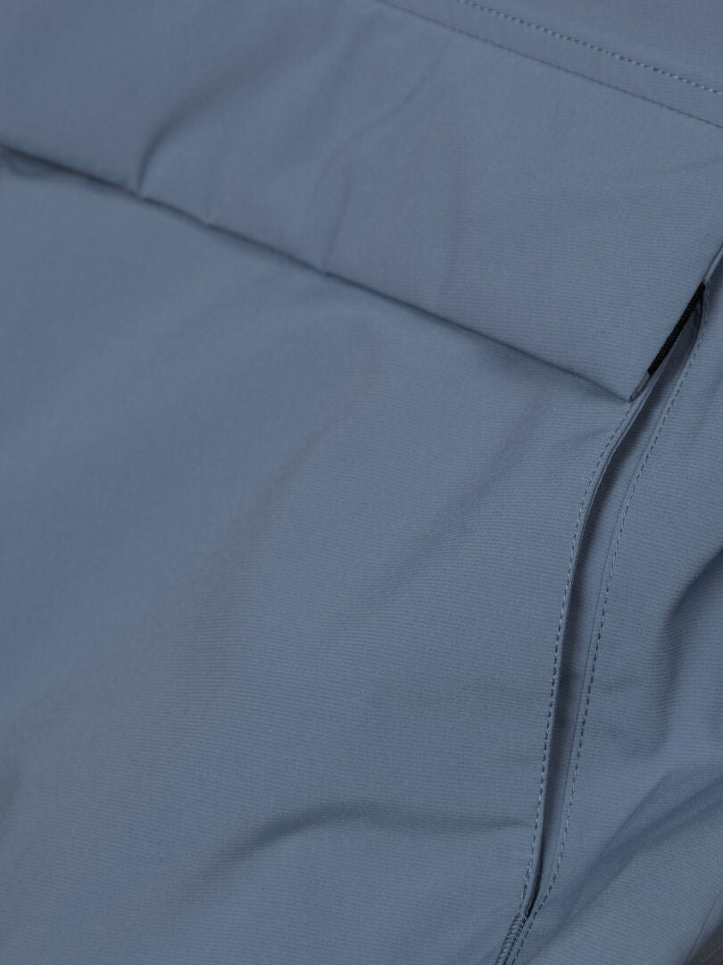 Nahaufnahme des „Halti Kortteli DX Insulated Parka Damen“ in Hellblau, mit Nähten und rechteckiger Taschenklappe.