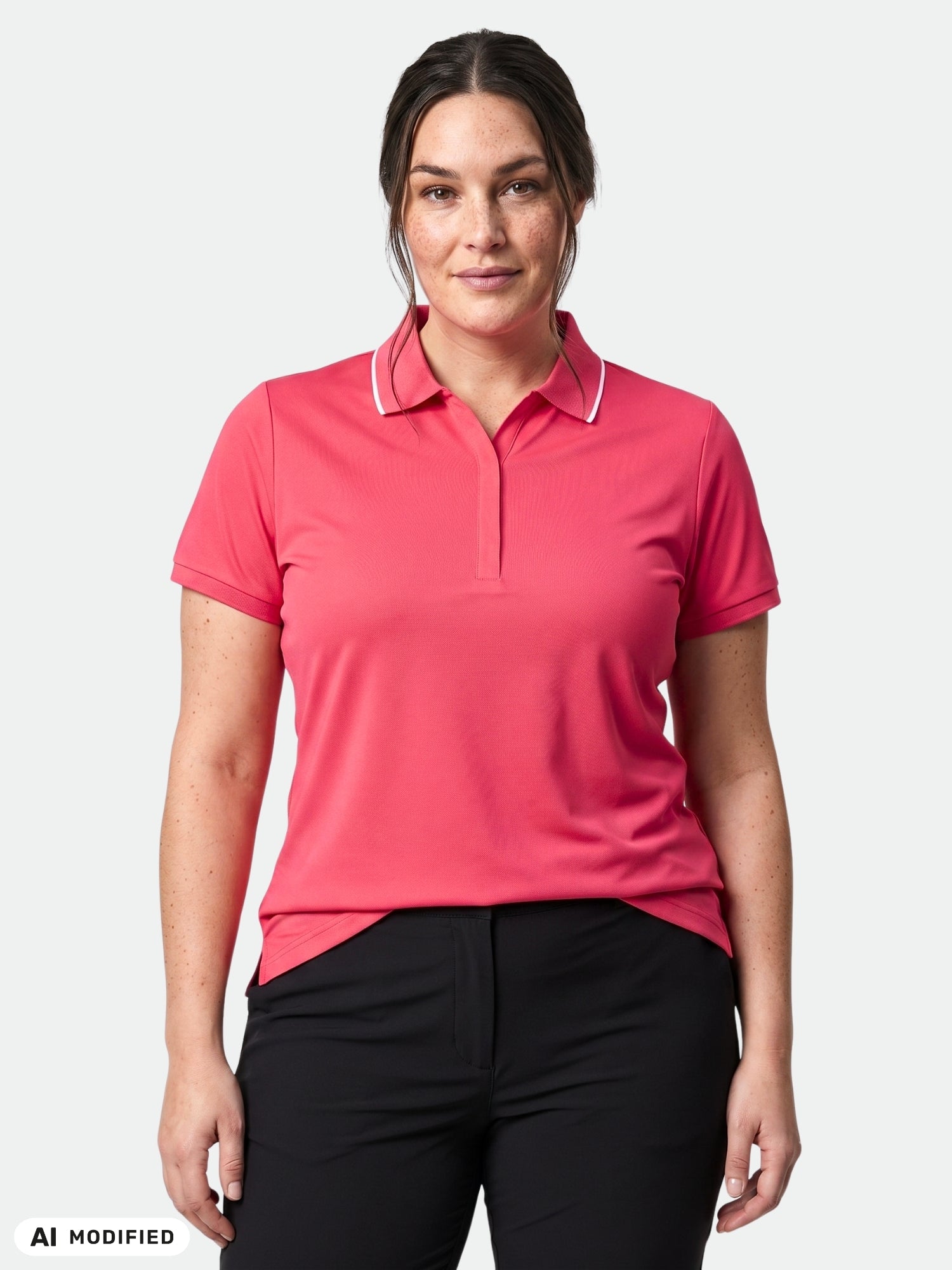 Frau in einem „Halti Swingi Technisches Poloshirt Damen Plus“ mit kurzen Ärmeln und einer schwarzen Hose vor weißem Hintergrund.