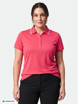 Frau in einem „Halti Swingi Technisches Poloshirt Damen Plus“ mit kurzen Ärmeln und einer schwarzen Hose vor weißem Hintergrund.