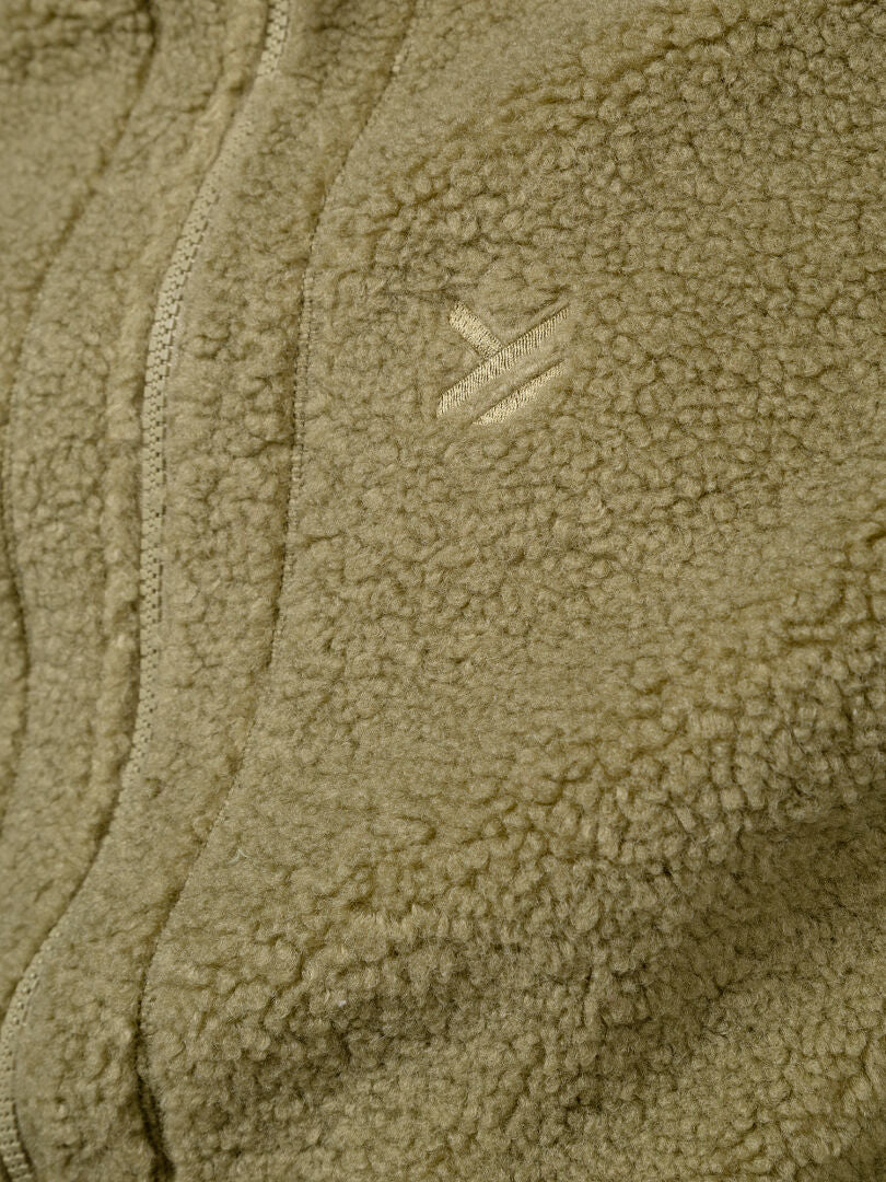Nahaufnahme der hellbraunen Halti Lykky Fleece-Weste (Unisex) aus recyceltem Polyester, mit Reißverschluss vorne und kleinem Logo auf der Brust.