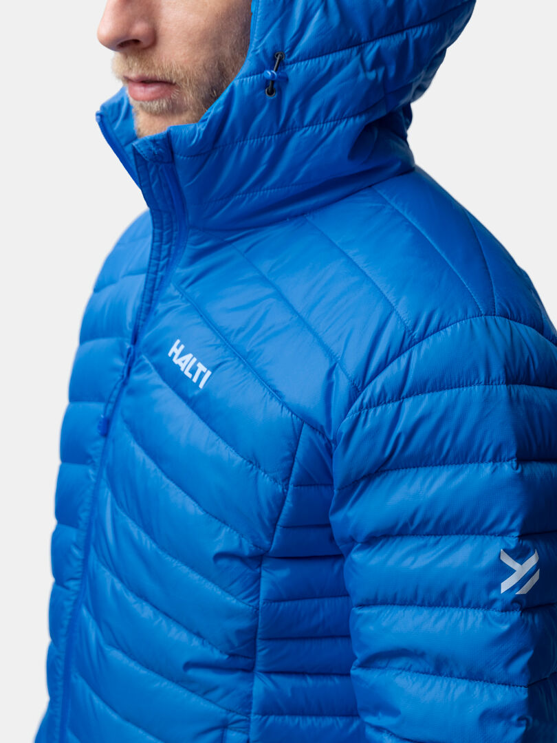 Eine Person in einer hellblauen Halti Huippu Daunenjacke Herren mit Kapuze, ideal für Outdoor-Aktivitäten.