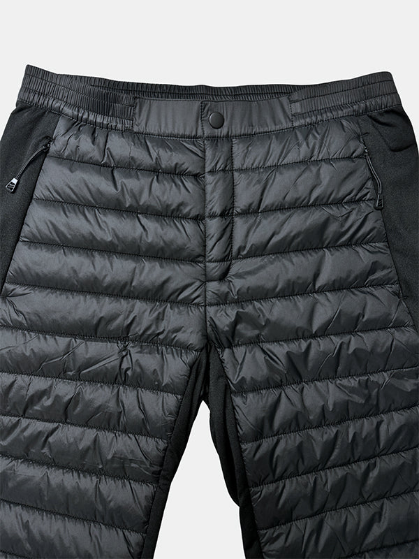 Nahaufnahme von Halti Veidnes Insulation Hosen Damen Plus: schwarze Stepphose mit Reißverschlusstaschen und elastischem Druckknopfbund.